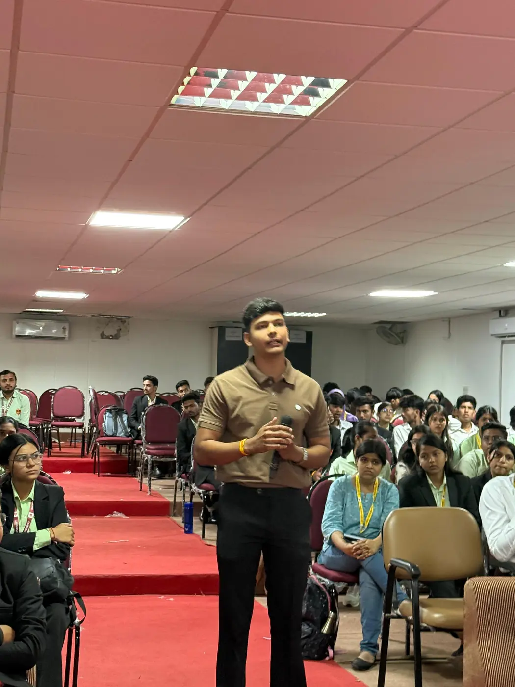 An educator taking questions from students in an auditorium