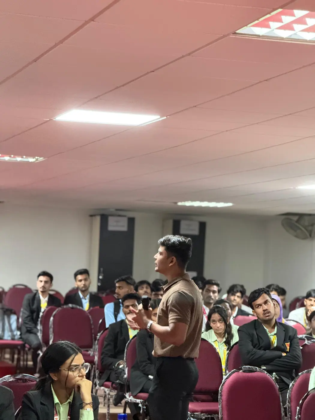 An educator speaking to students in an auditorium