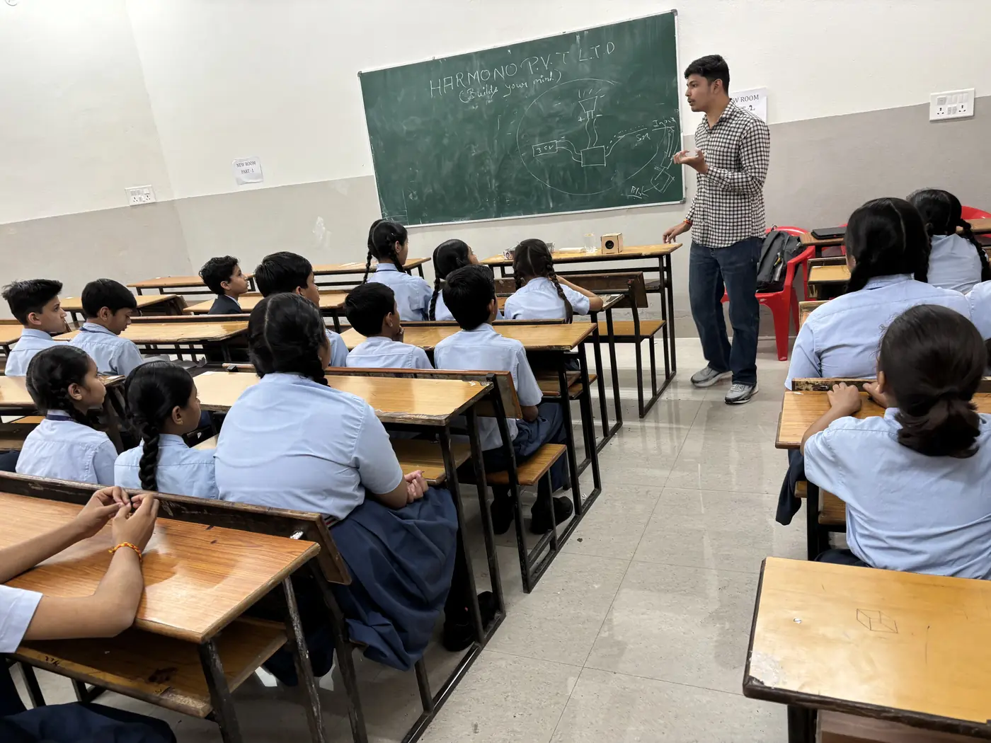 A Builds Your Mind educator explaining a circuit diagram to school students in a classroom