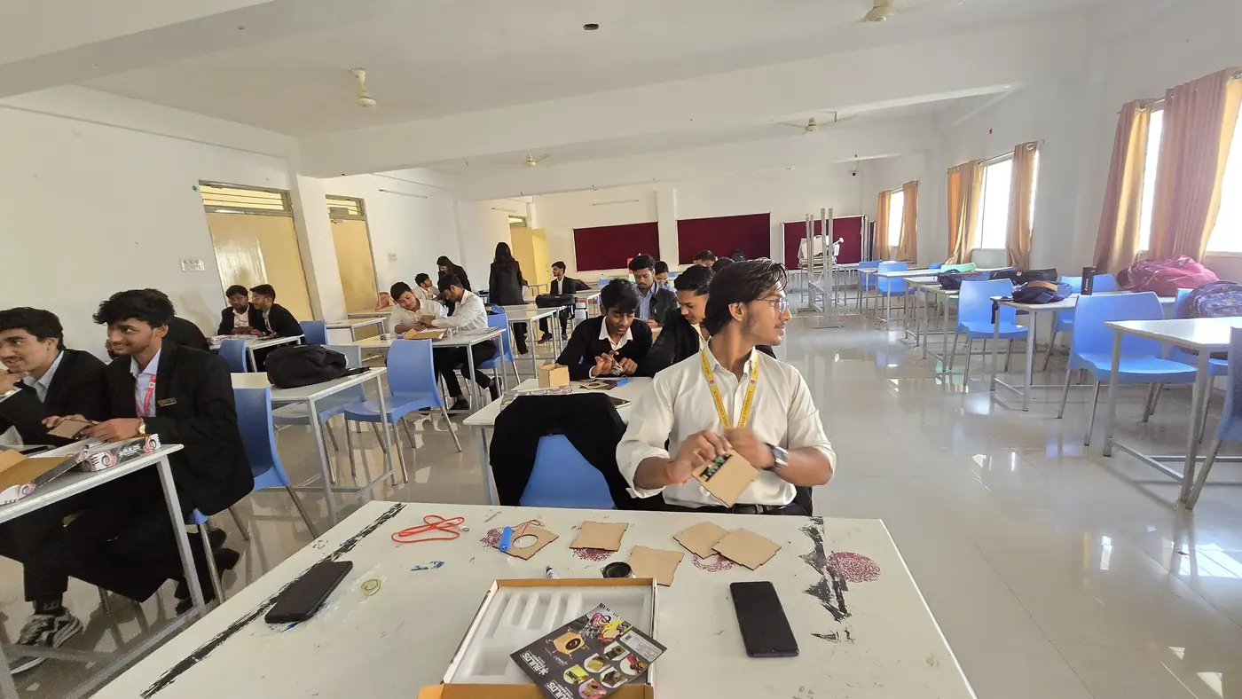 A Builds Your Mind educator with kits and parts laid out on a table in front of a class