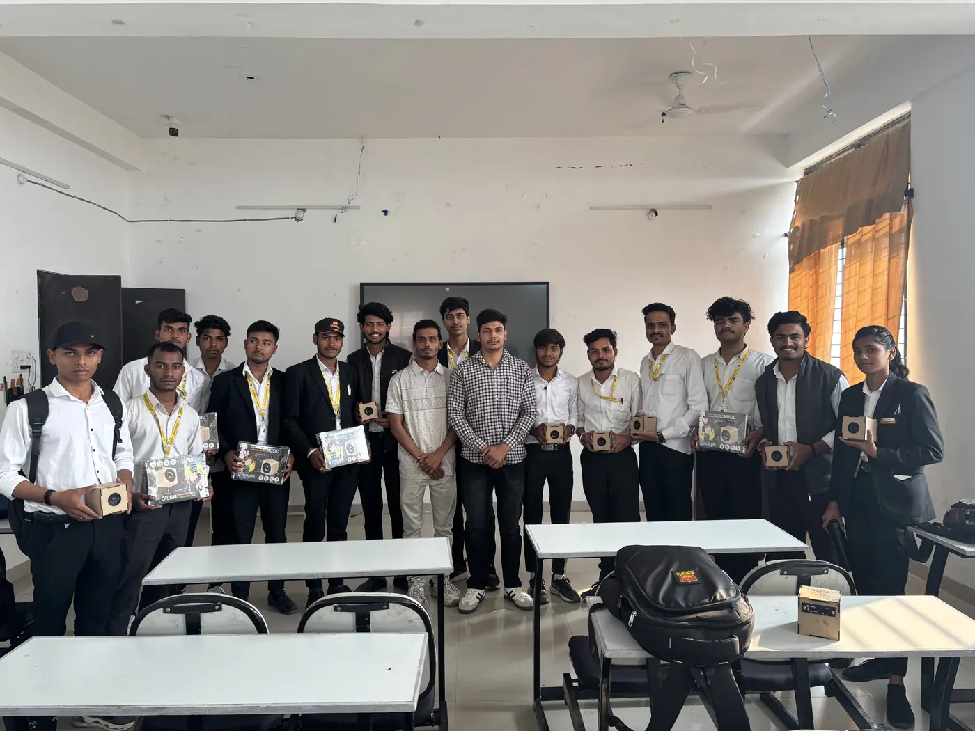 Engineering students holding completed workshop project kits in a classroom