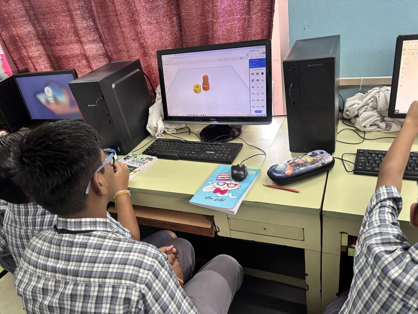 A school student designing a 3D model on a lab computer