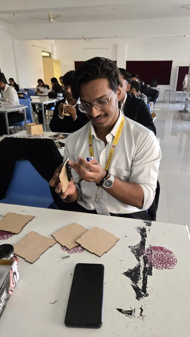 A student assembling a cardboard project kit at a desk