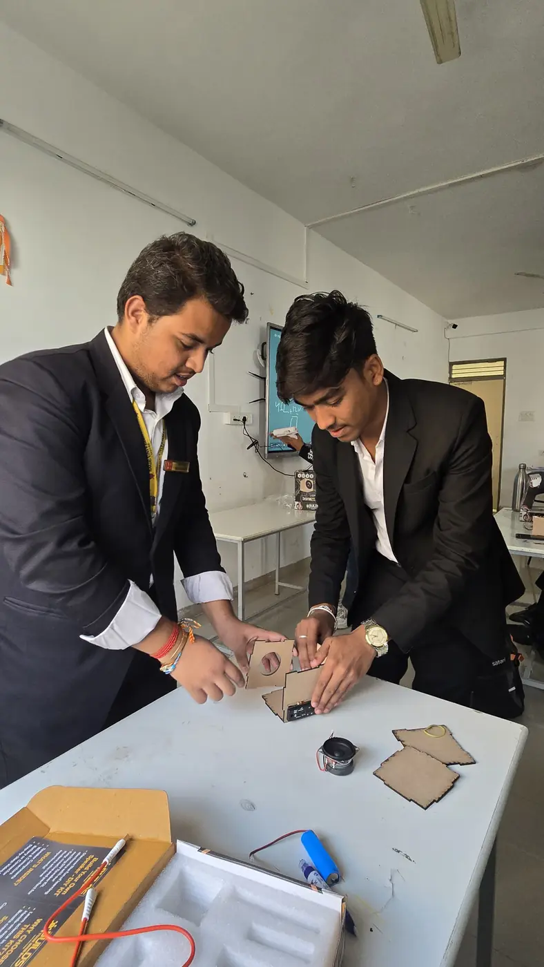 Two students assembling a kit together at a table