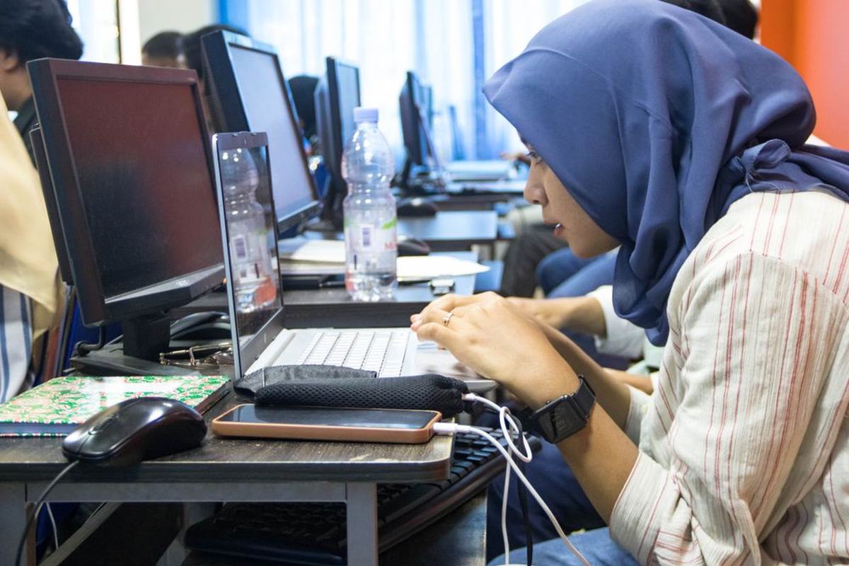 A student working at a computer in a college computer lab