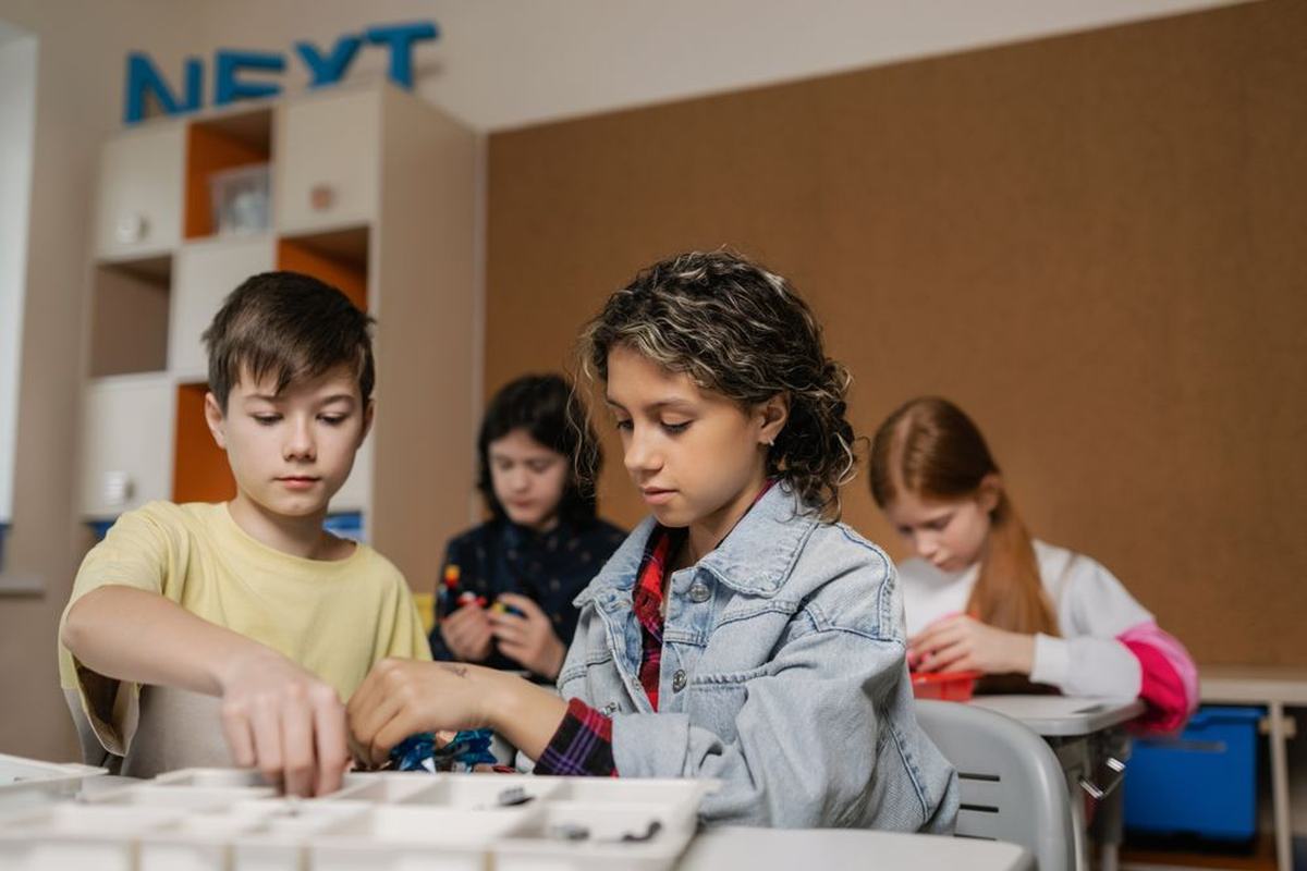 Children assembling parts of a project together at a table in a learning lab